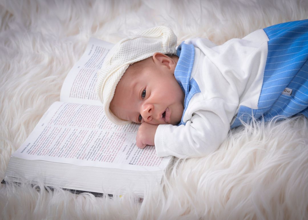 Recién nacido dormido con gorrito blanco y detalles azules